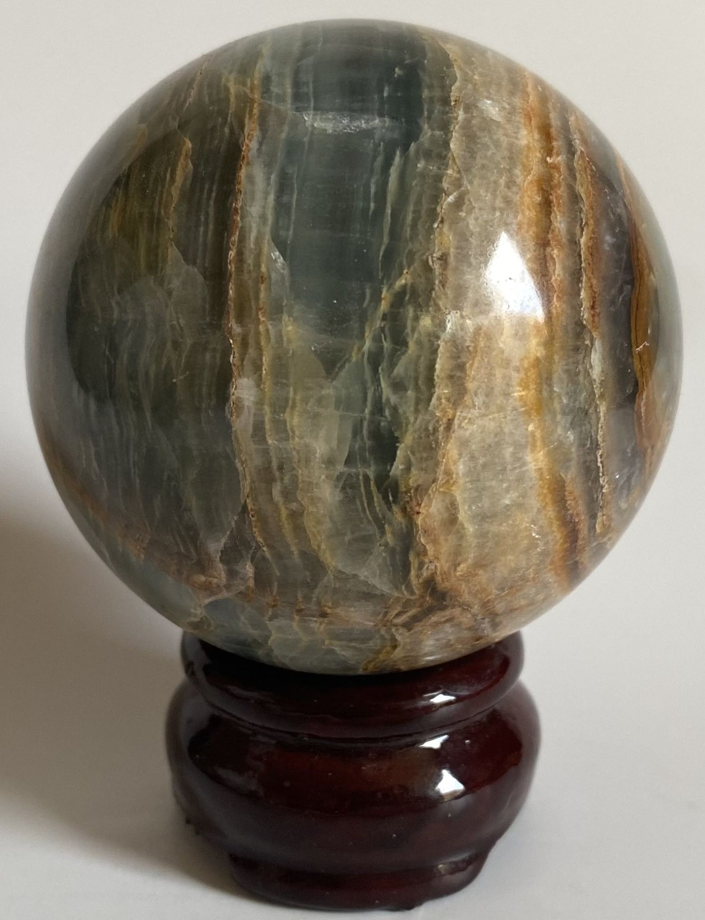 Sfera decorativa de 6.4cm din piatra semipretioasa de onix albastru pe suport din lemn cu fundal alb