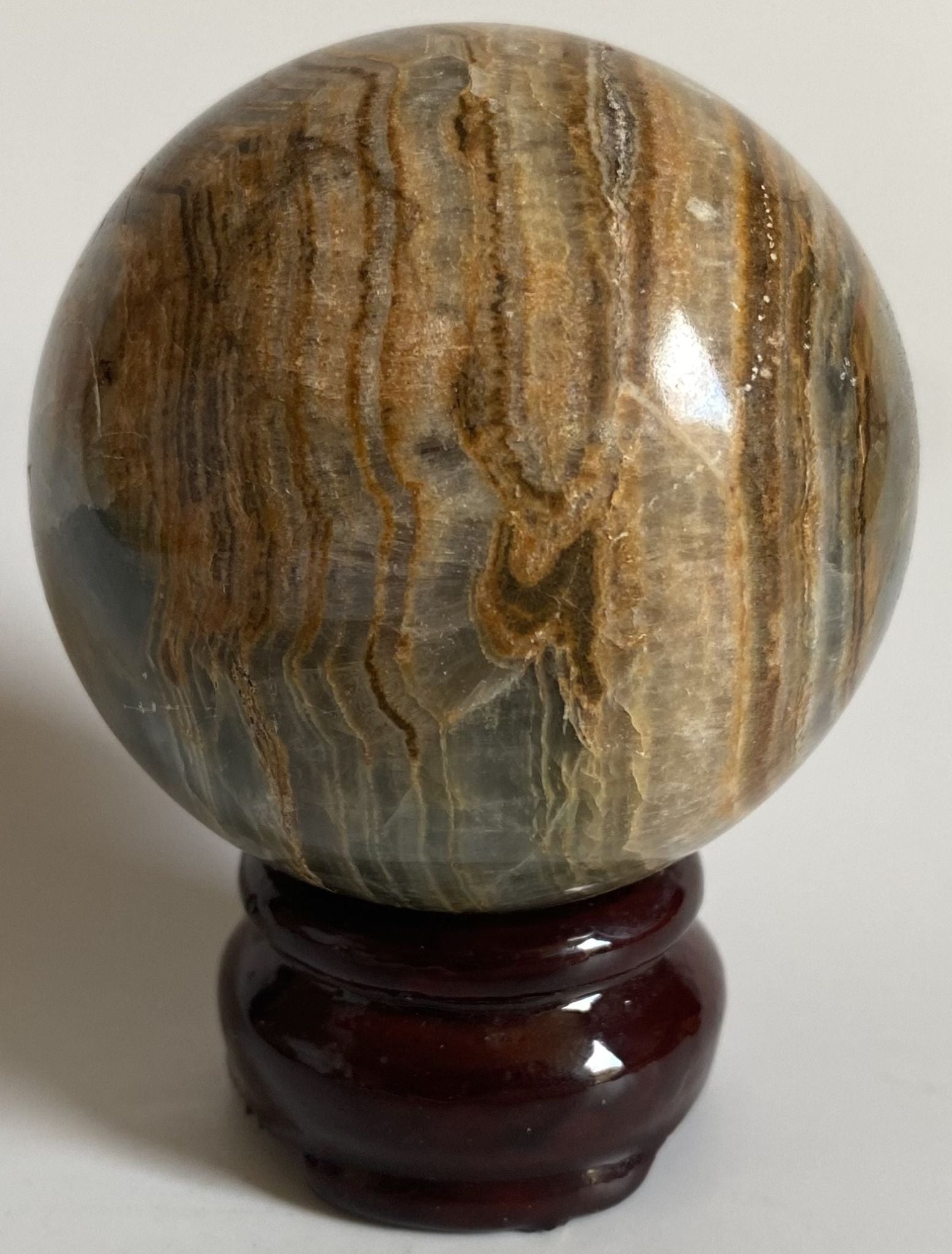 Sfera decorativa de 6.4cm din cristal de onix albastru pe suport din lemn cu fundal alb