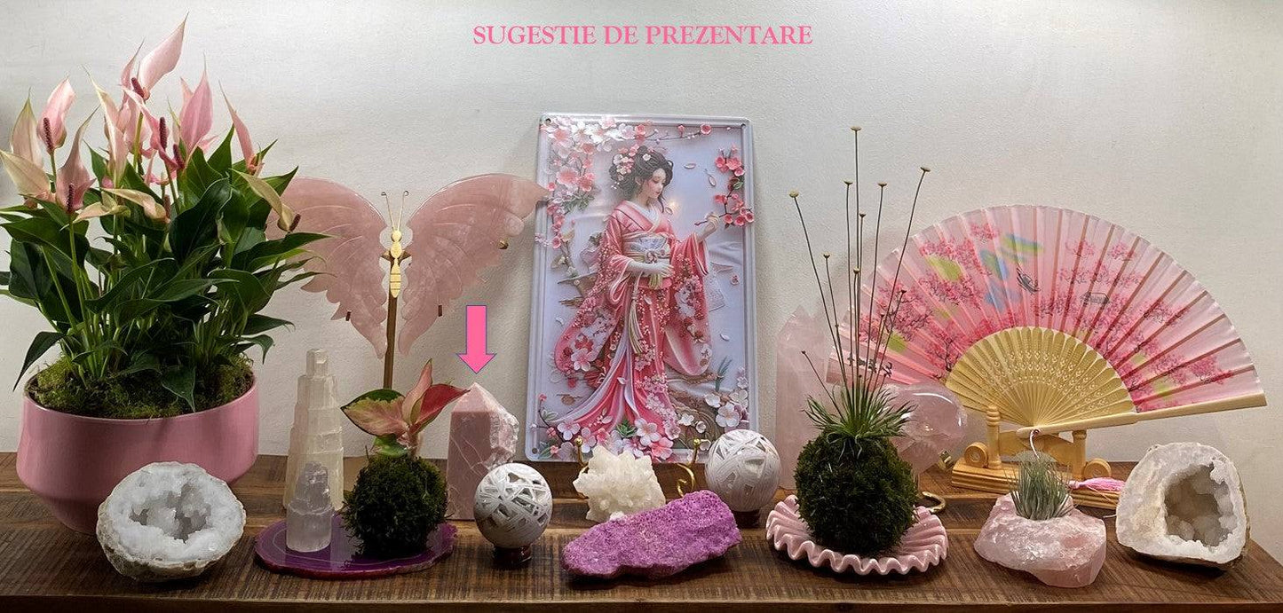 Opal Roz rough obelisk semiprecious stone displayed among decorative items including plants, fans, and crystal spheres