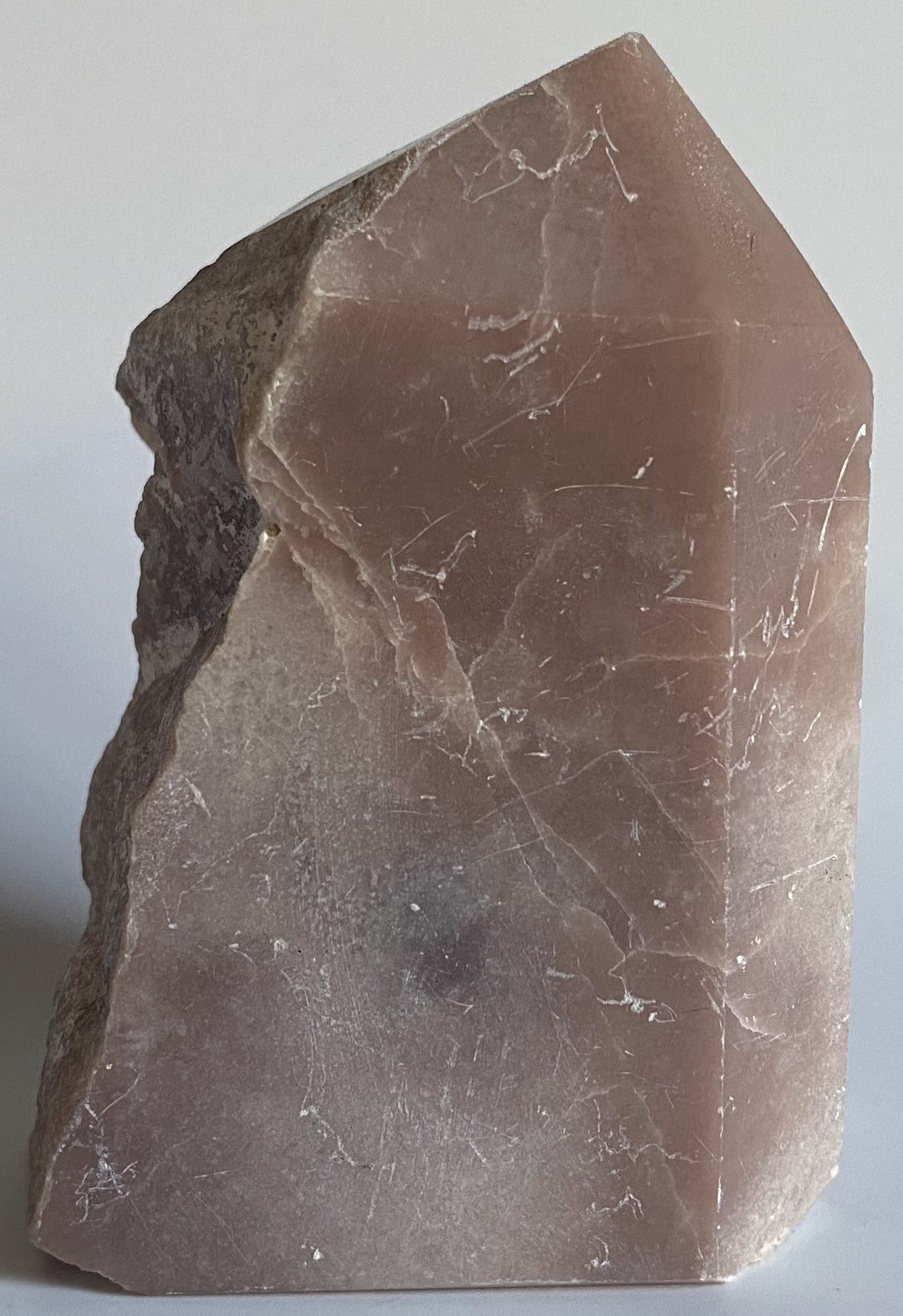 Obelisc brut din cristal de opal roz pe fundal alb