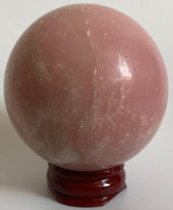 Sfera de 5.7cm din piatra semipretioasa de opal roz pe suport din lemn cu fundal alb