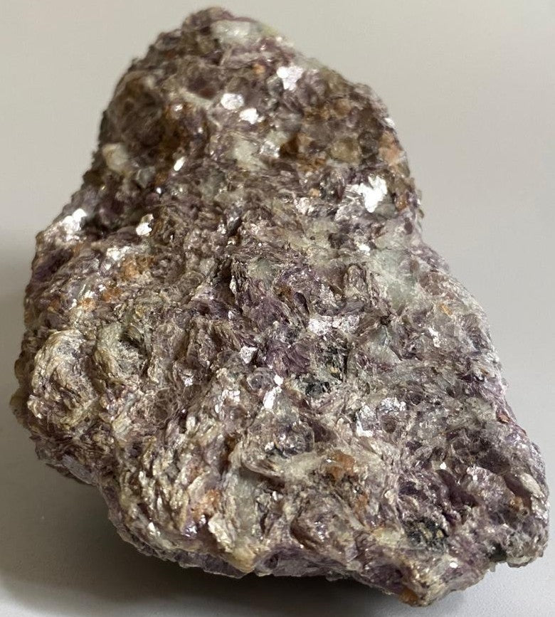 Piatra bruta din cristal de muscovit roz pe fundal alb