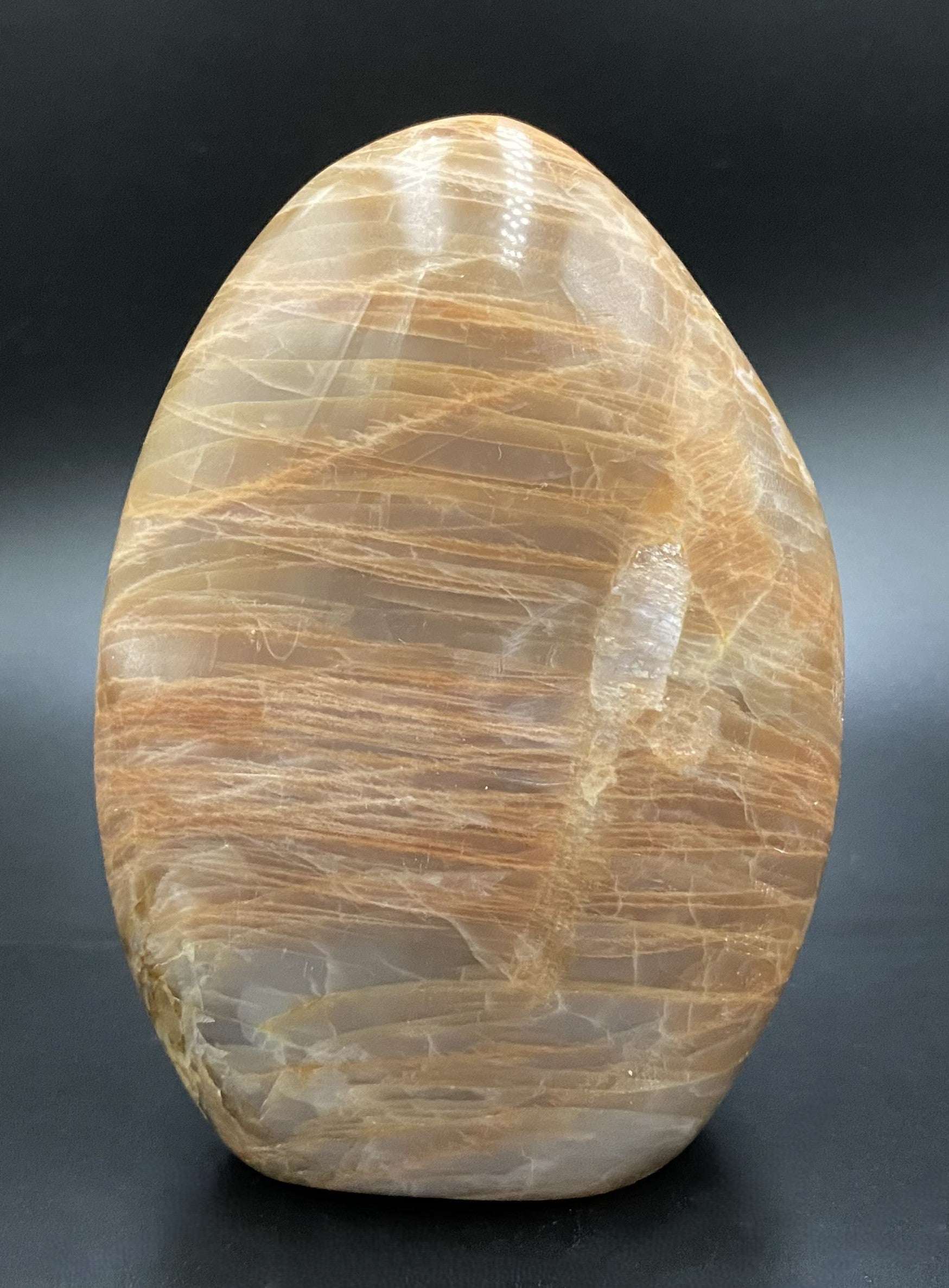 Piatra Lunii Piersica semiprecious stone sculpture with peach hues on black background