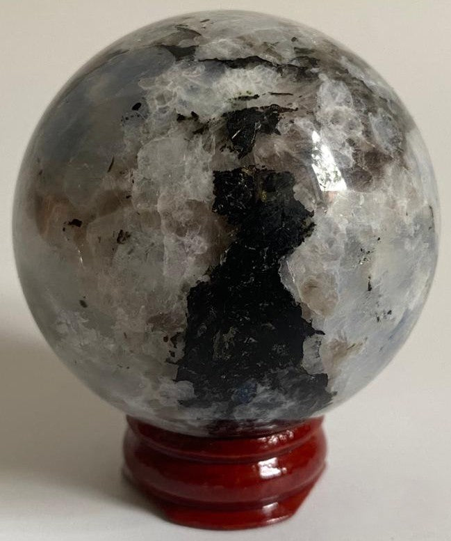 Sfera din cristal de piatra lunii rainbow pe suport din lemn cu fundal alb