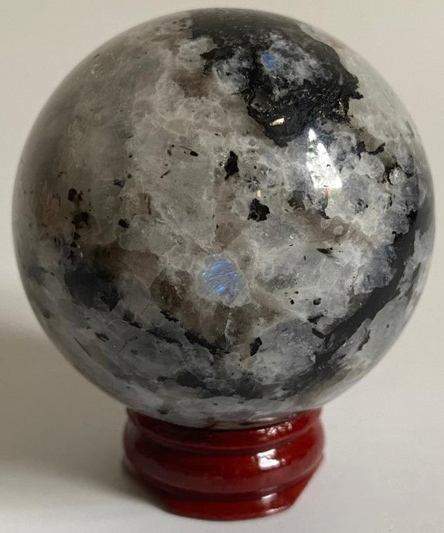 Sfera de 5.6cm din piatra semipretioasa de piatra lunii rainbow pe suport din lemn cu fundal alb