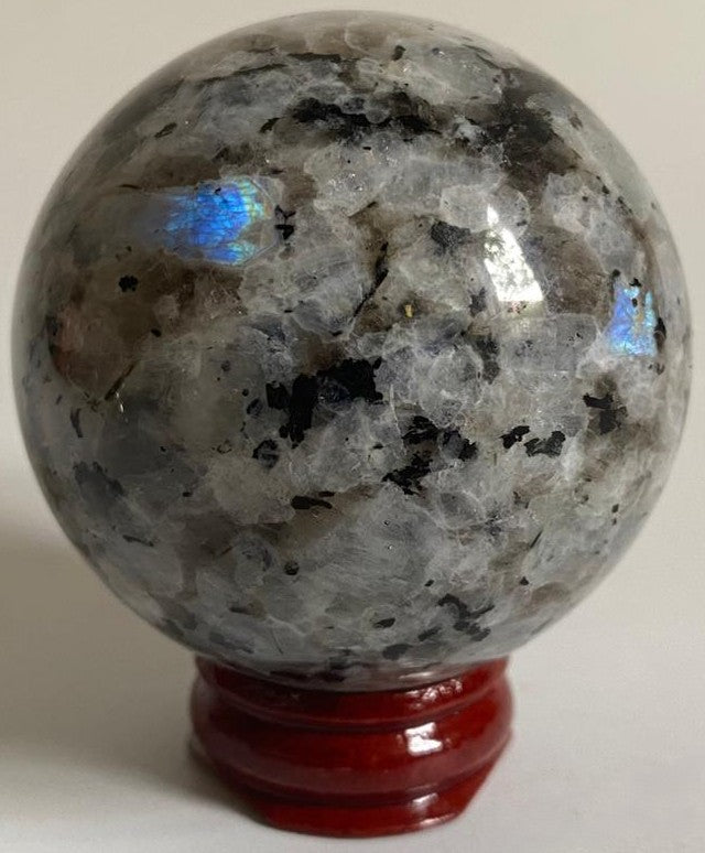 Sfera de 5.6cm din cristal de piatra lunii rainbow pe suport din lemn cu fundal alb