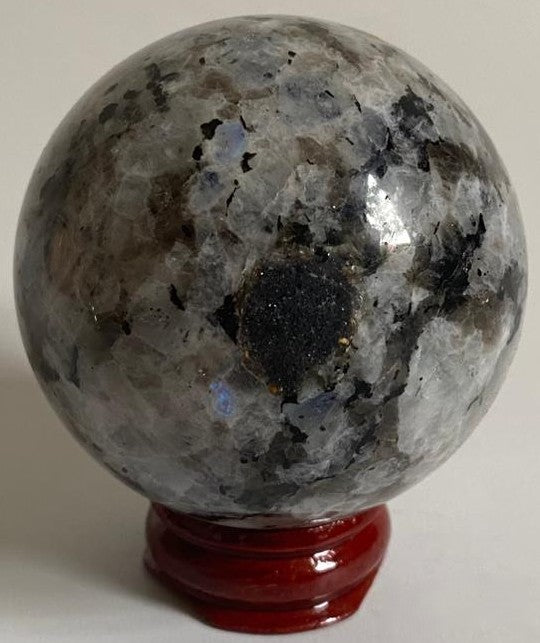 Sfera unicat de 5.6cm din piatra semipretioasa de piatra lunii rainbow pe suport din lemn cu fundal alb