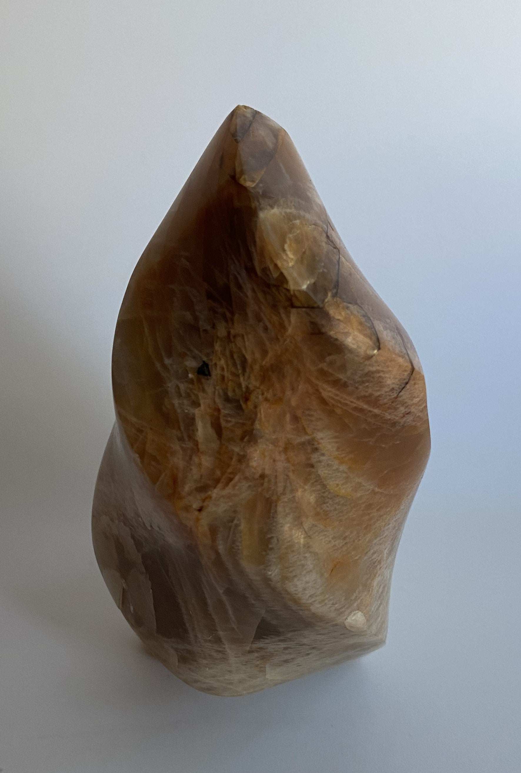 Sculptura din piatra lunii portocalie semipretioasa naturala pe fundal alb