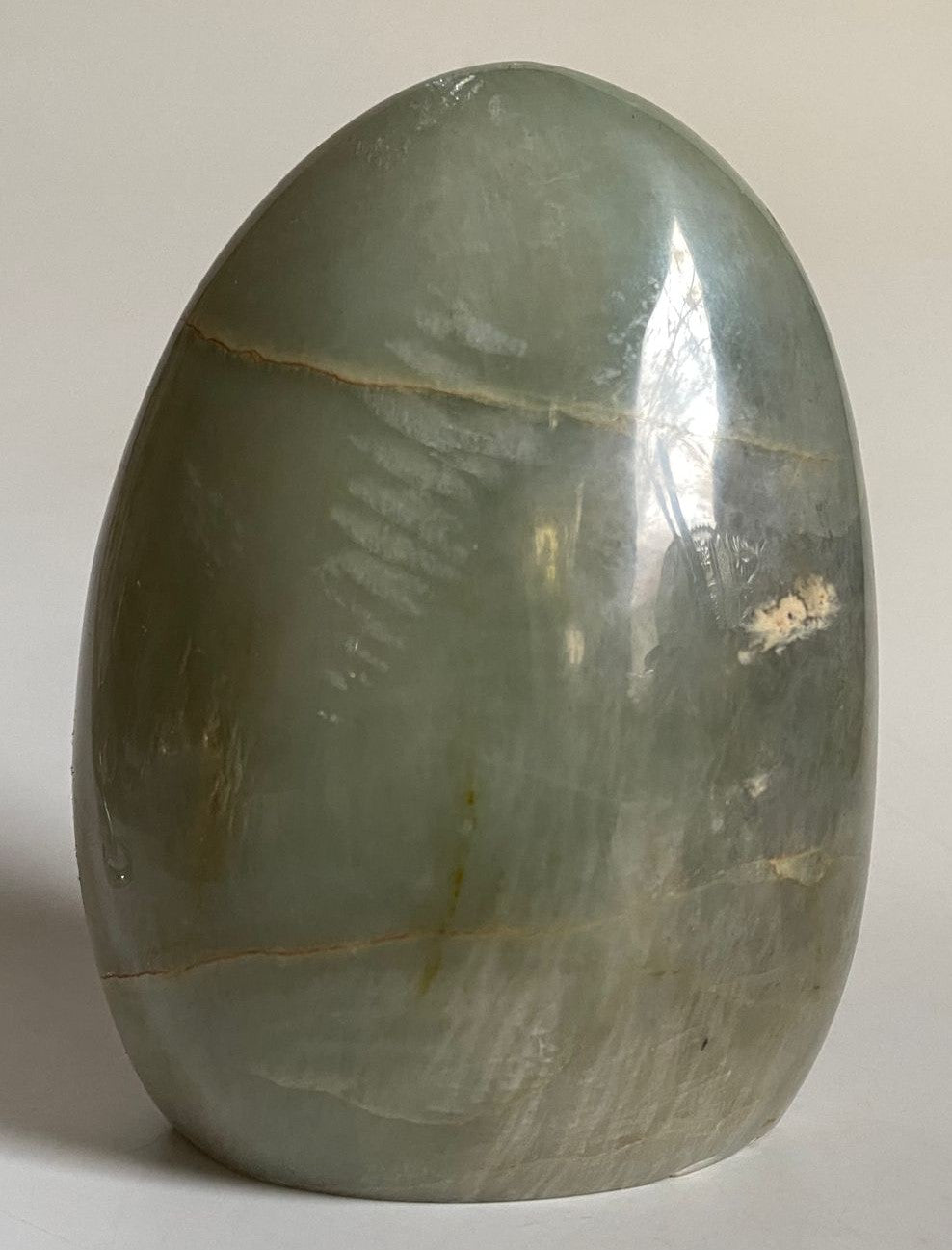 Sculptura din cristal de piatra lunii verde pe fundal alb