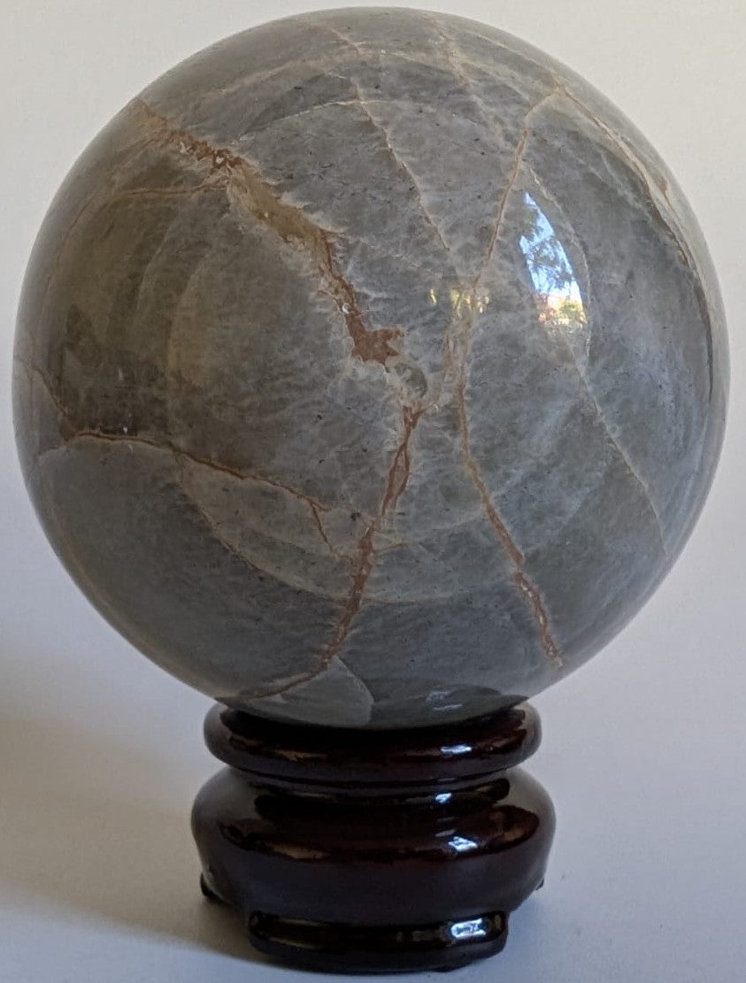 Sfera decorativa de 7.1cm din piatra semipretioasa de piatra lunii verde pe suport din lemn cu fundal alb