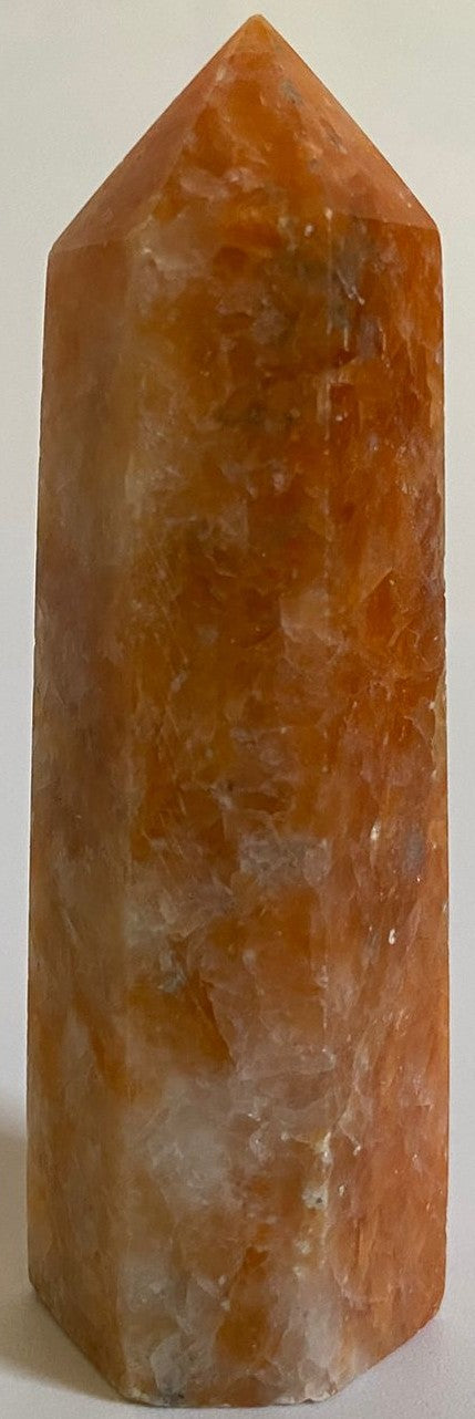 Obelisc din cristal de piatra soarelui pe fundal alb