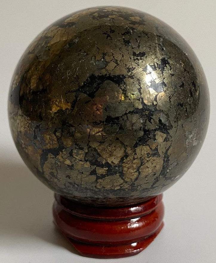 Sfera de 5cm din piatra semipretioasa de pirita pe suport din lemn cu fundal alb
