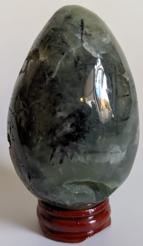 Ou de 7.5cm din cristal de prehnit pe suport din lemn cu fundal alb