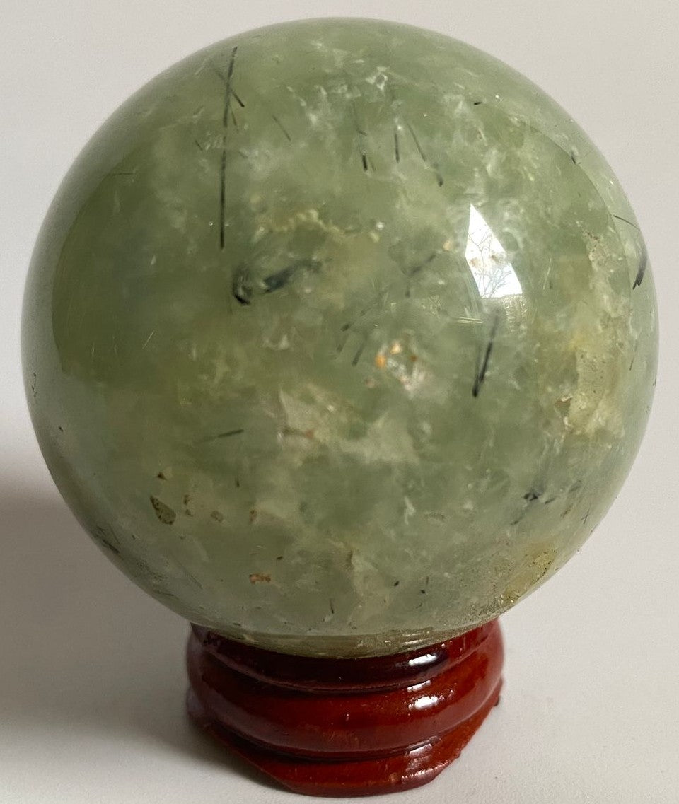 Sfera de 5.4cm din piatra semipretioasa de prehnit pe suport din lemn cu fundal alb