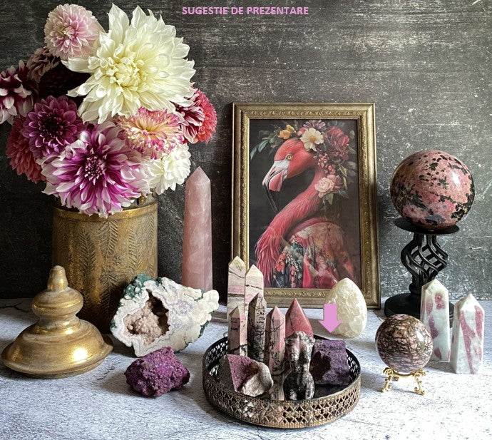 Specimen piatra bruta Purpurit stone displayed with crystals and floral decor on table