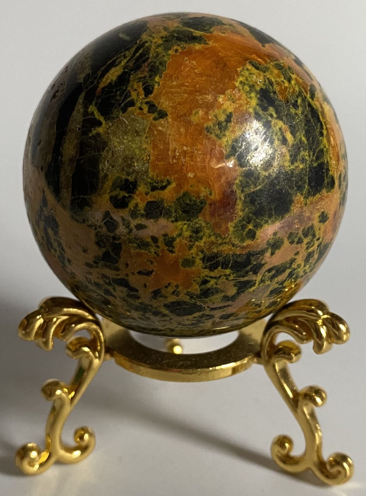 Sfera de 5.2cm din piatra semipretioasa de realgar pe suport din metal cu fundal alb