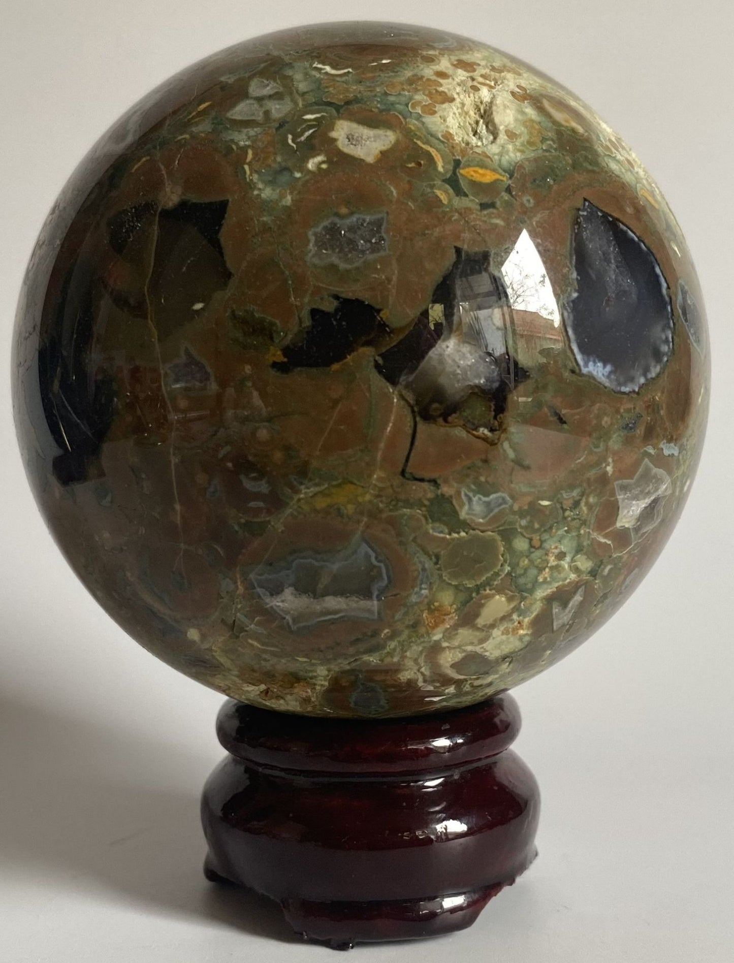 Sfera din cristal de riolit pe suport din lemn cu fundal alb