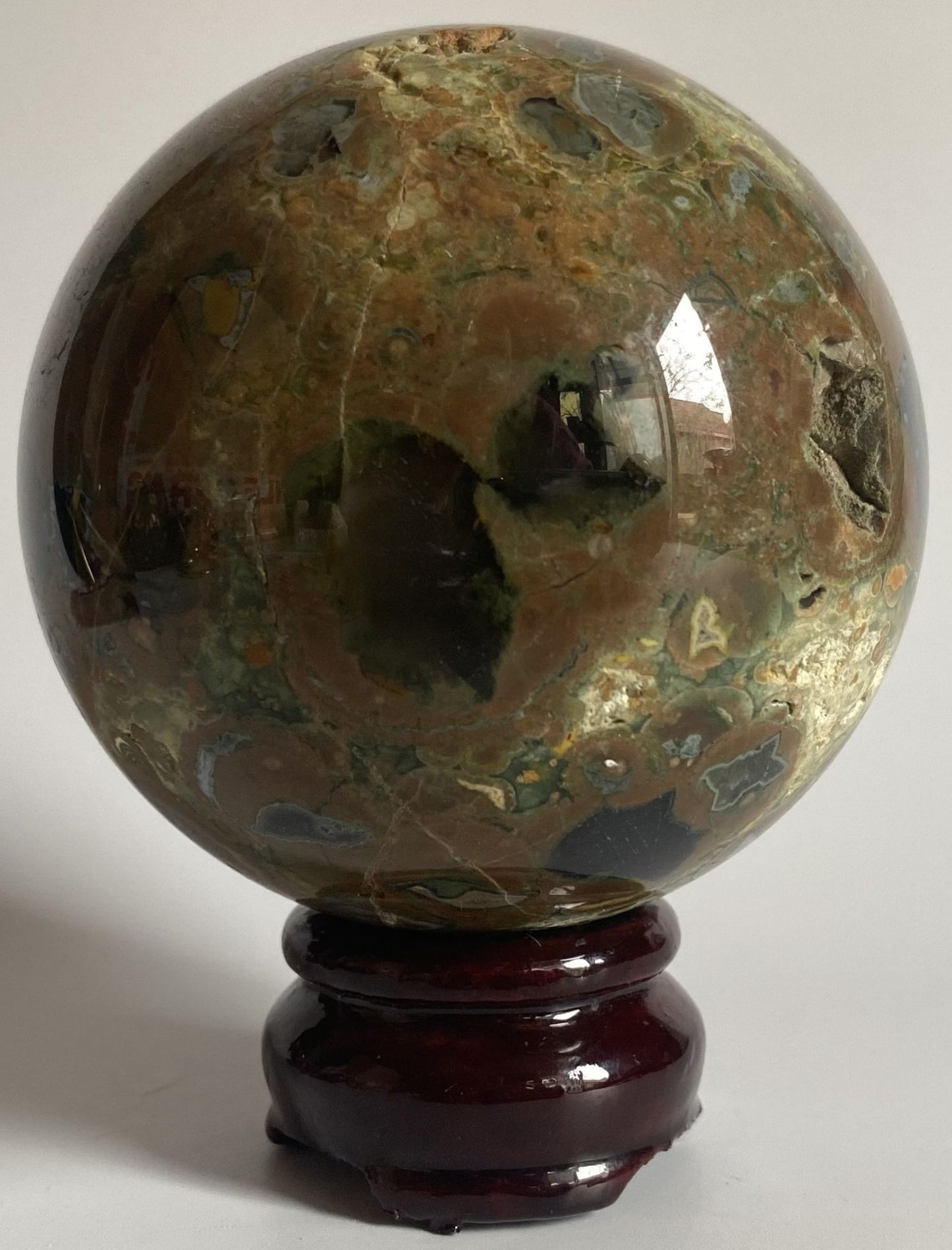 Sfera de 8cm din cristal de riolit pe suport din lemn cu fundal alb
