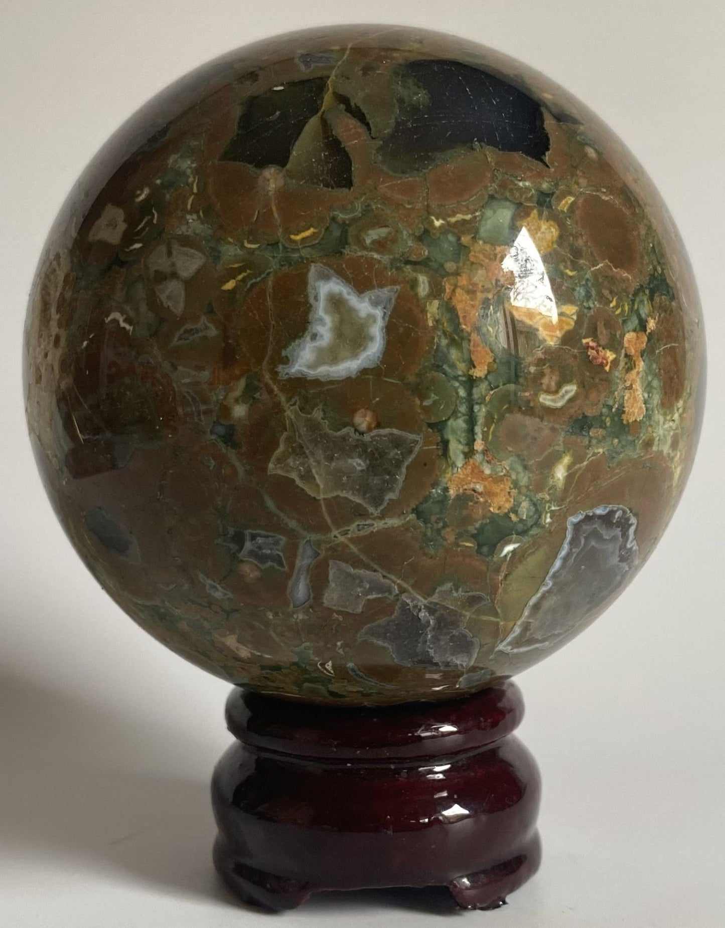 Sfera decorativa de 8cm din cristal de riolit pe suport din lemn cu fundal alb