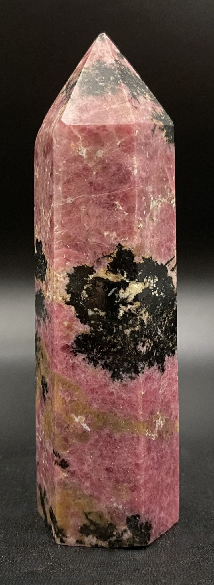 Obelisc din piatra semipretioasa de rodonit pe fundal negru