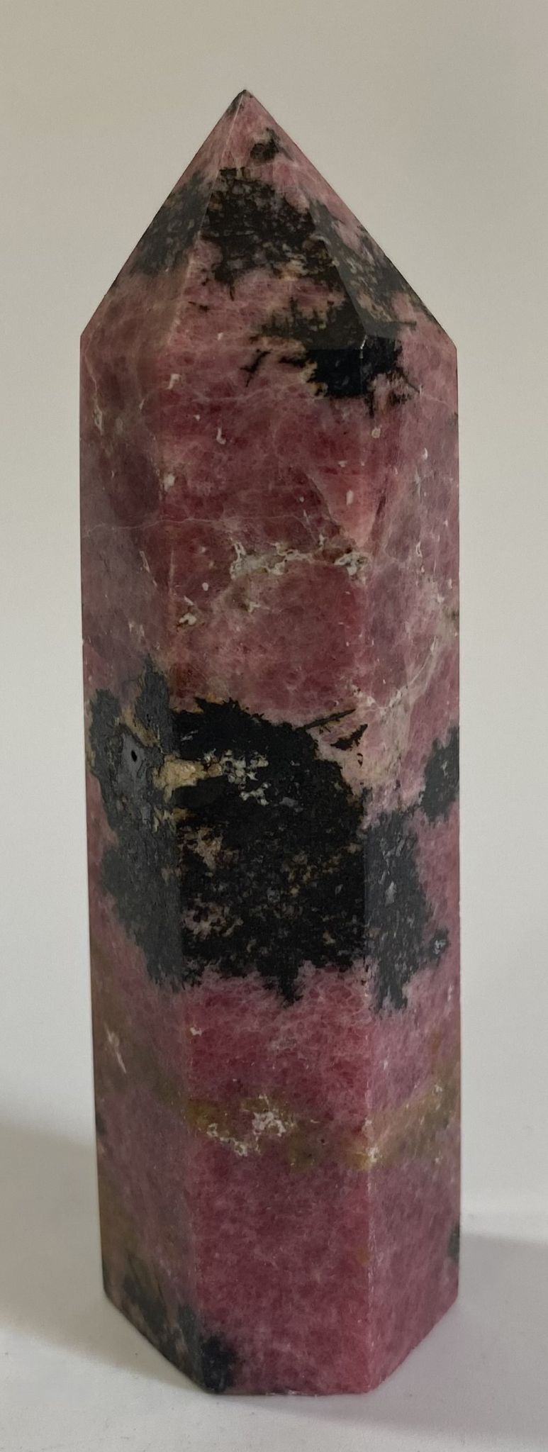 Obelisc din piatra semipretioasa de rodonit pe fundal alb