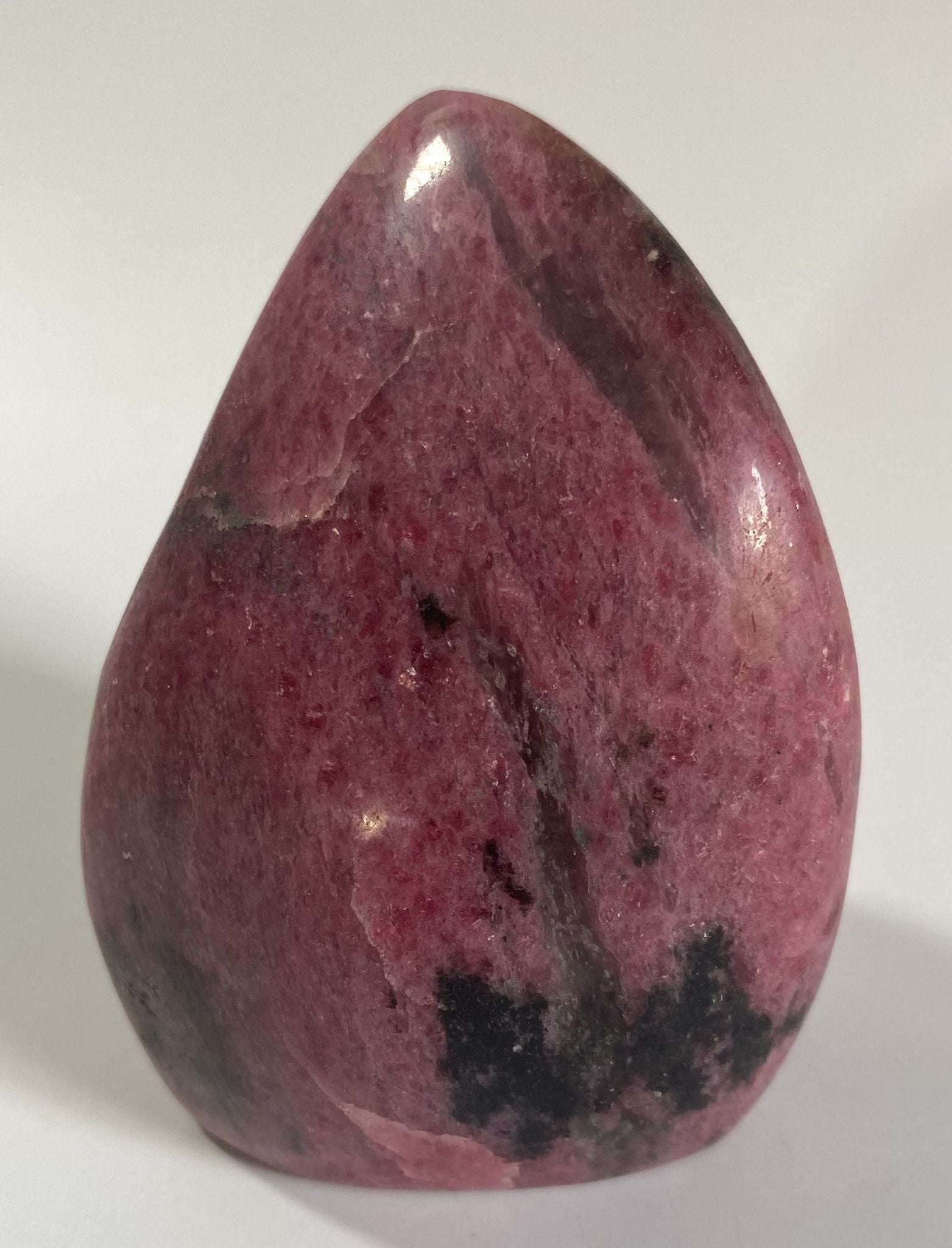 Sculptura de 9cm din piatra semipretioasa de rodonit pe fundal alb