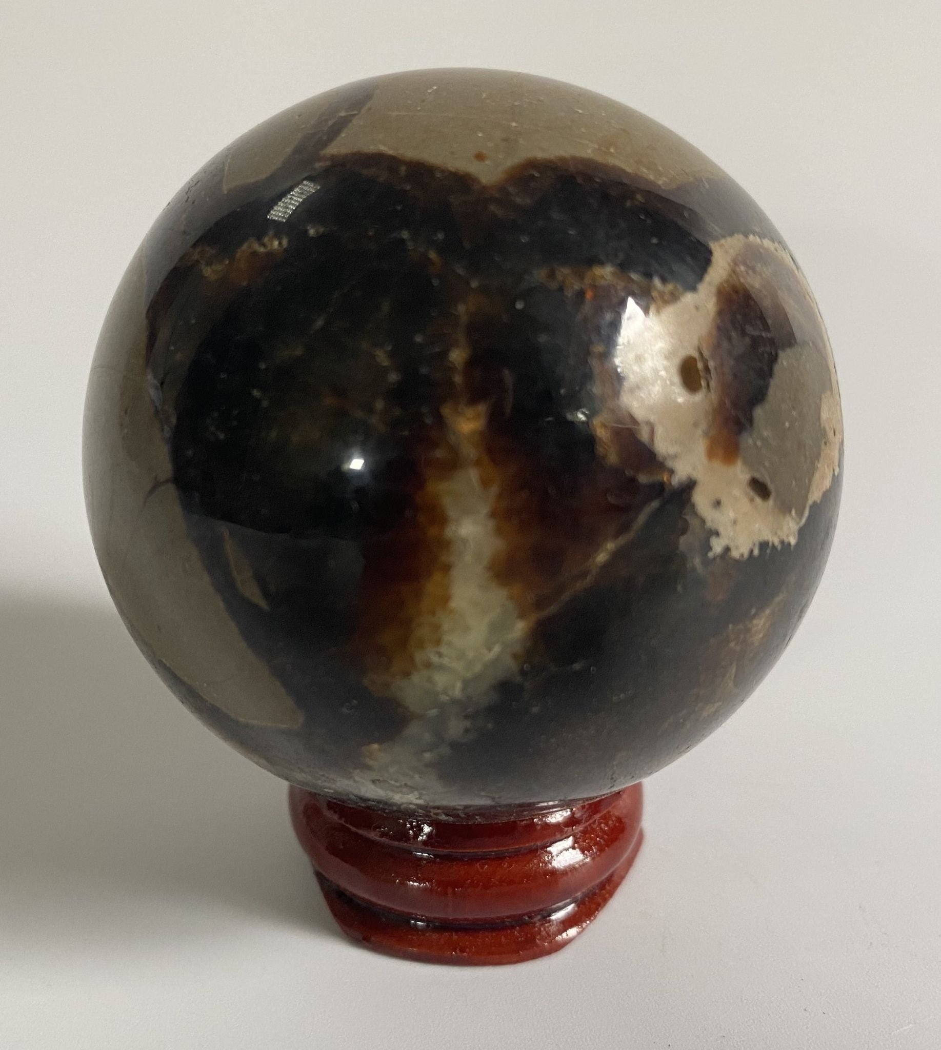 Sfera de 5.5cm din piatra semipretioasa de septaria pe suport din lemn cu fundal alb