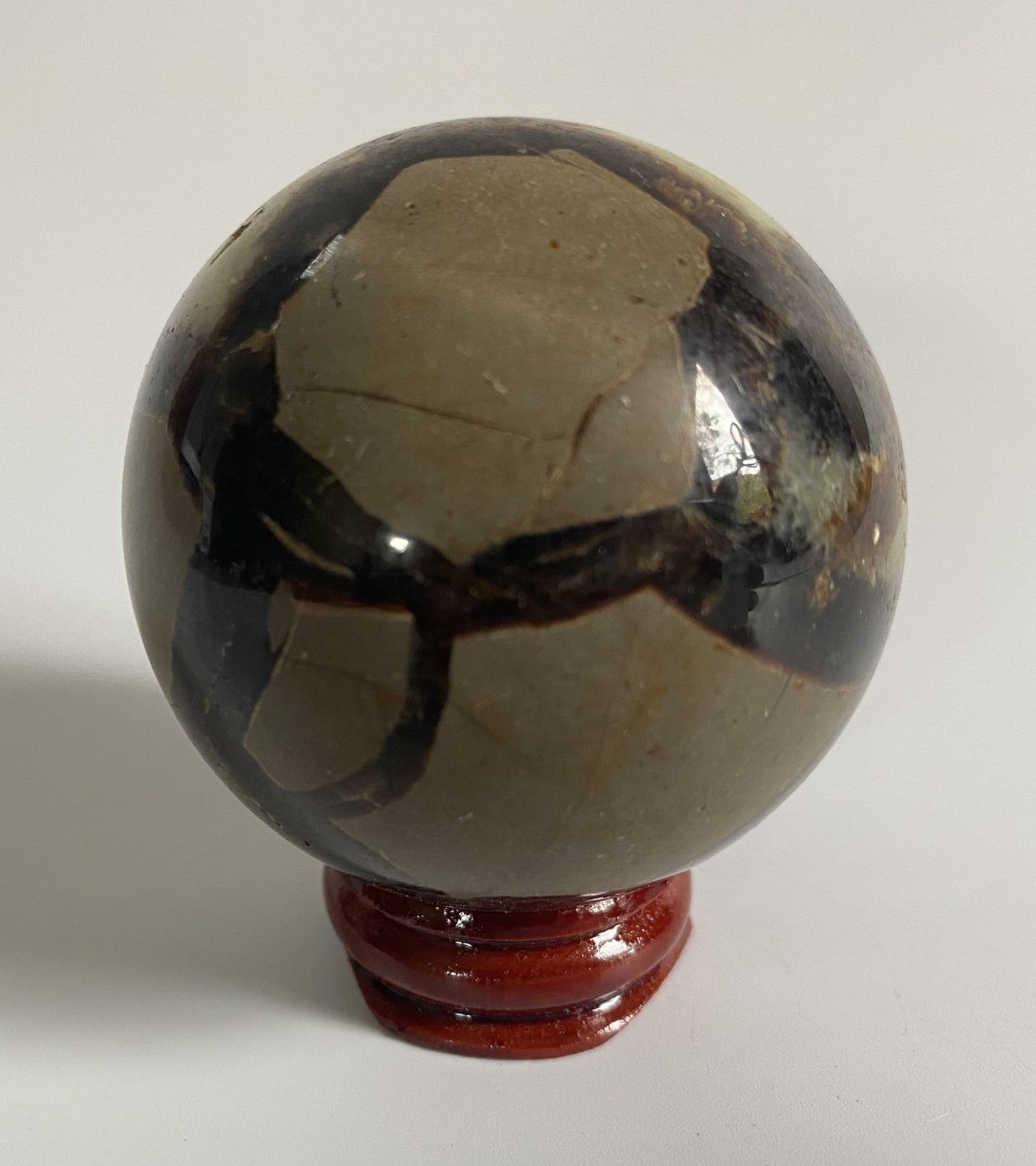 Sfera de 5.5cm din cristal de septaria pe suport din lemn cu fundal alb