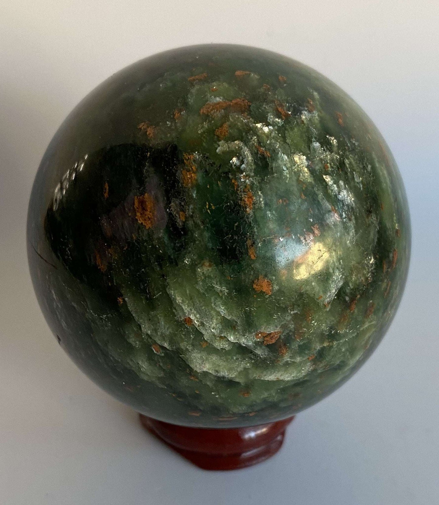 Corindon in Zoisit green gemstone sphere with wooden stand and natural floral patterns