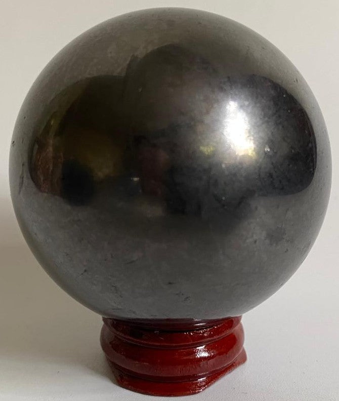 Sfera de 6cm din piatra semipretioasa de shungit pe suport din lemn cu fundal alb