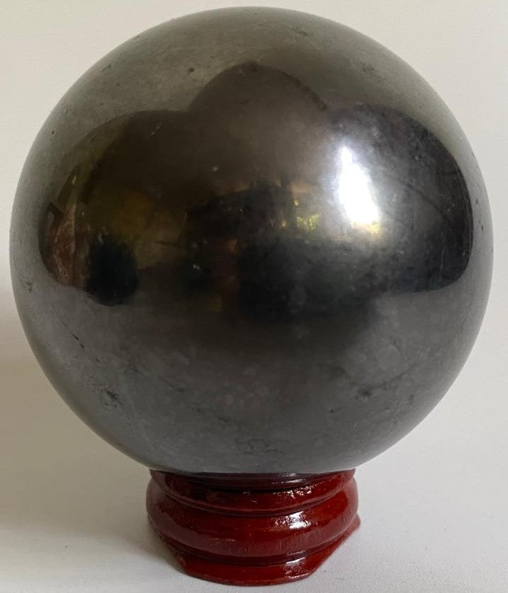Sfera de 6cm din cristal de shungit pe suport din lemn cu fundal alb