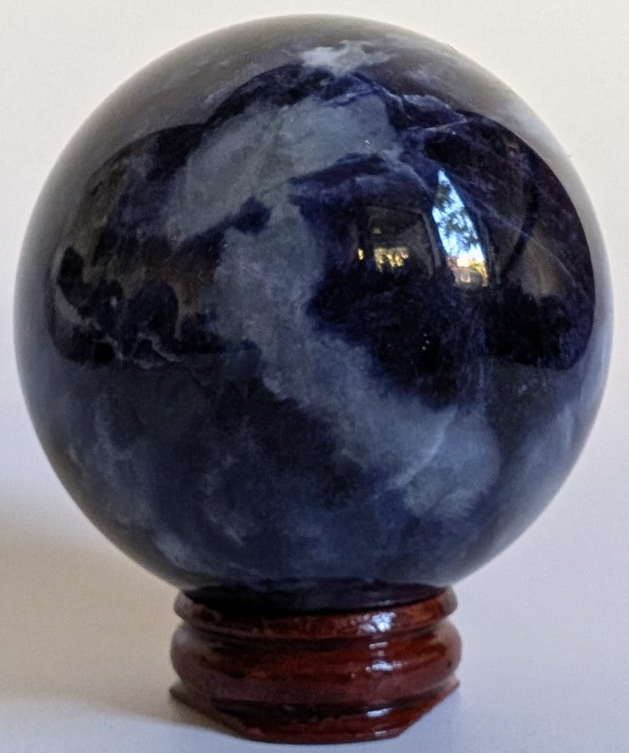 Sfera de 5.7cm din piatra semipretioasa de sodalit pe suport din lemn cu fundal alb