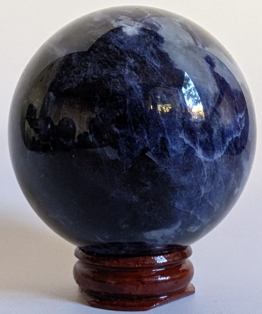 Sfera decorativa de 5.7cm din cristal de sodalit pe suport din lemn cu fundal alb