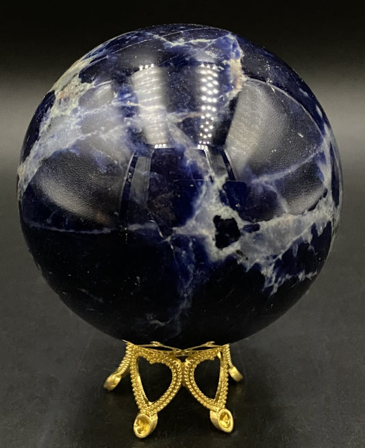 Sfera din Sodalit pe suport metalic auriu pe fond negru sub lumina artificiala