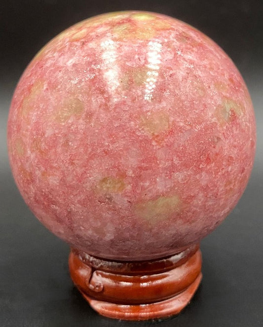 Sfera din piatra semipretioasa de thulit pe suport din lemn cu fundal negru