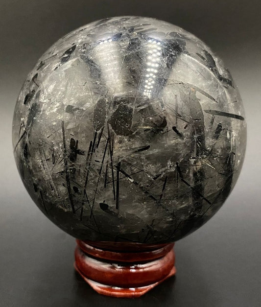 Sfera din piatra semipretioasa de turmalina cu cuart pe suport din lemn   cu fundal negru