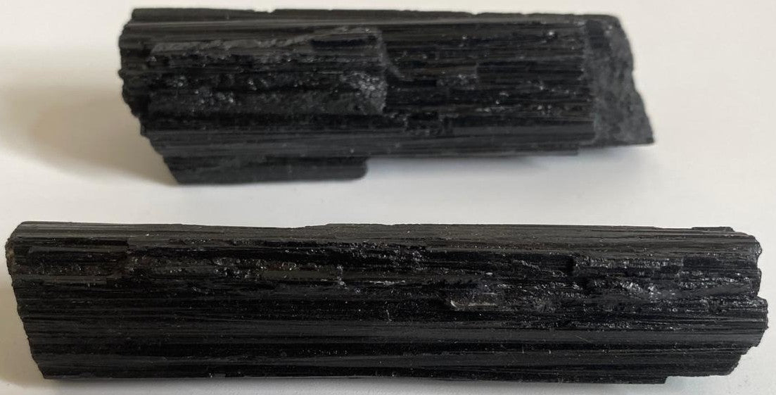 Piatra bruta din mineral de turmalina neagra pe fundal alb