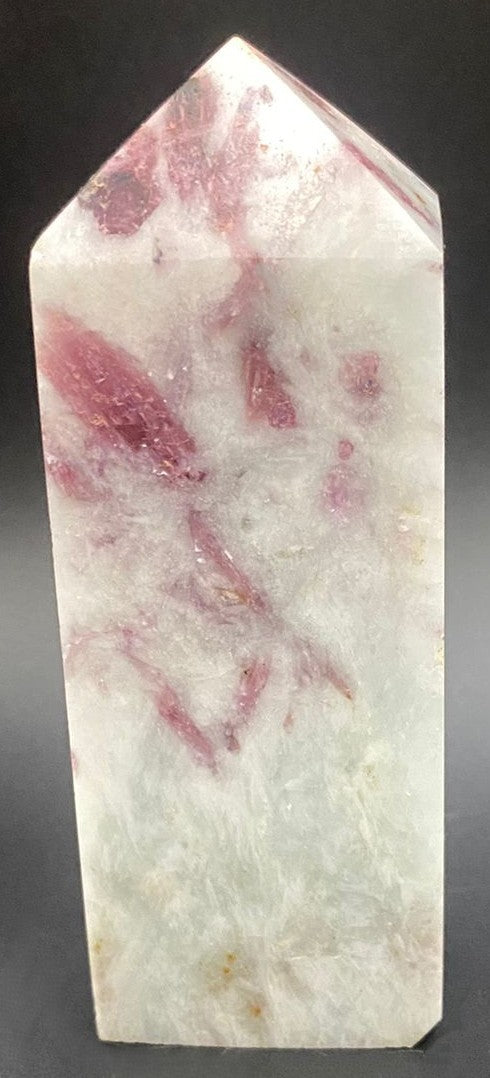 Obelisc din piatra semipretioasa de turmalina rosie pe fundal negru