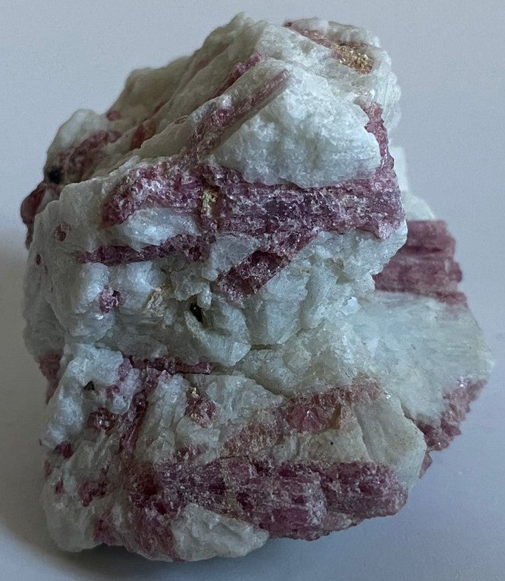 Piatra bruta de 6.4cm din piatra semipretioasa de turmalina rosie pe fundal alb