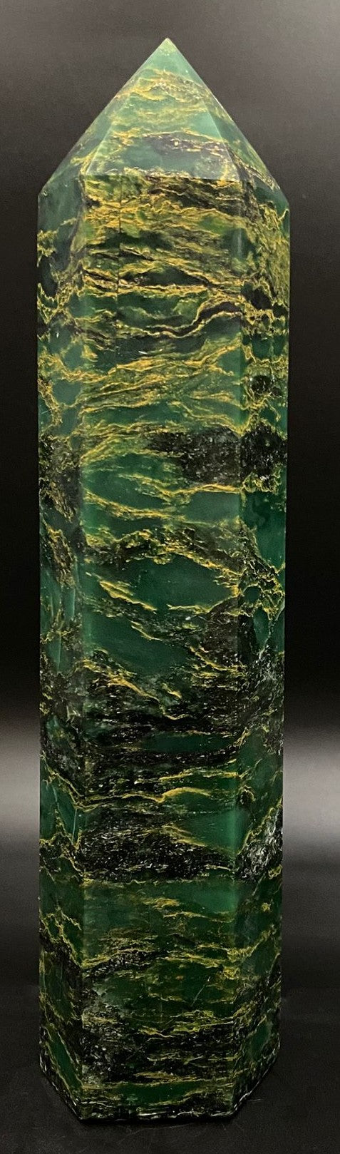 Obelisc din verdit pe fond negru sub lumina artificiala