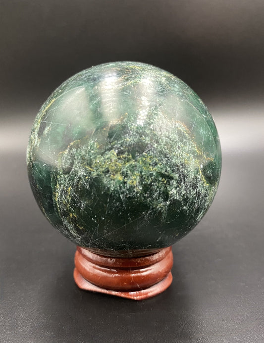 Sfera din piatra semipretioasa de verdit pe suport din lemn cu fundal negru
